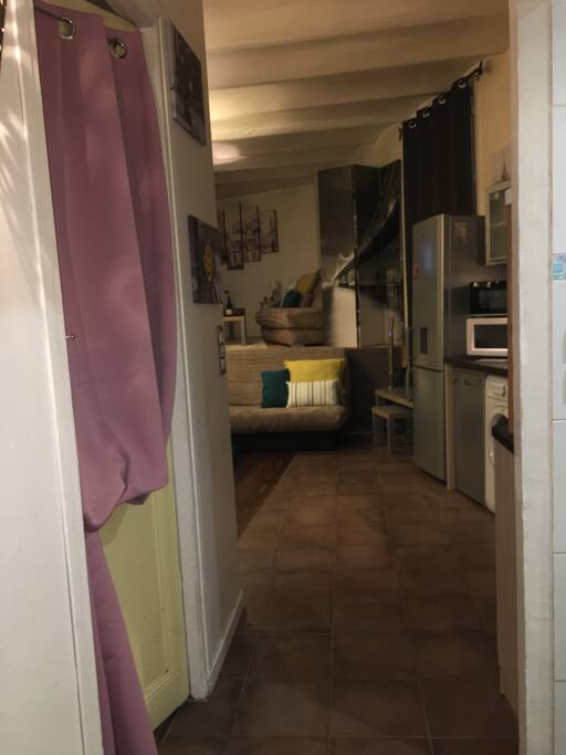 Entrée de l’appartement avec la porte de la chambre à gauche et la salle d’eau à droite.