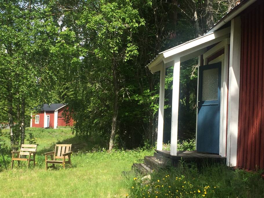 Mellan träden skymtar en gammal bagarstuga (woods and a view of a old bakerhouse)