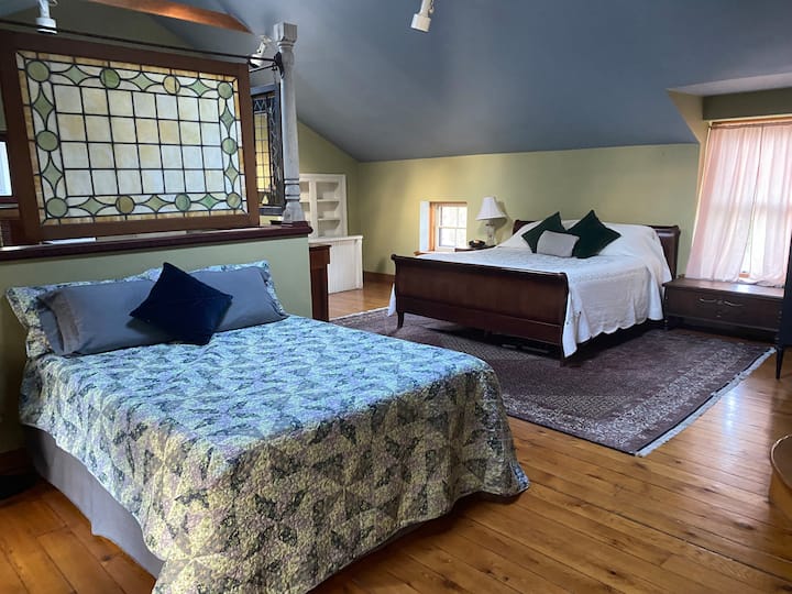 Chumba kikuu kina mfalme na kitanda cha kifalme na bafu kwenye chumba.