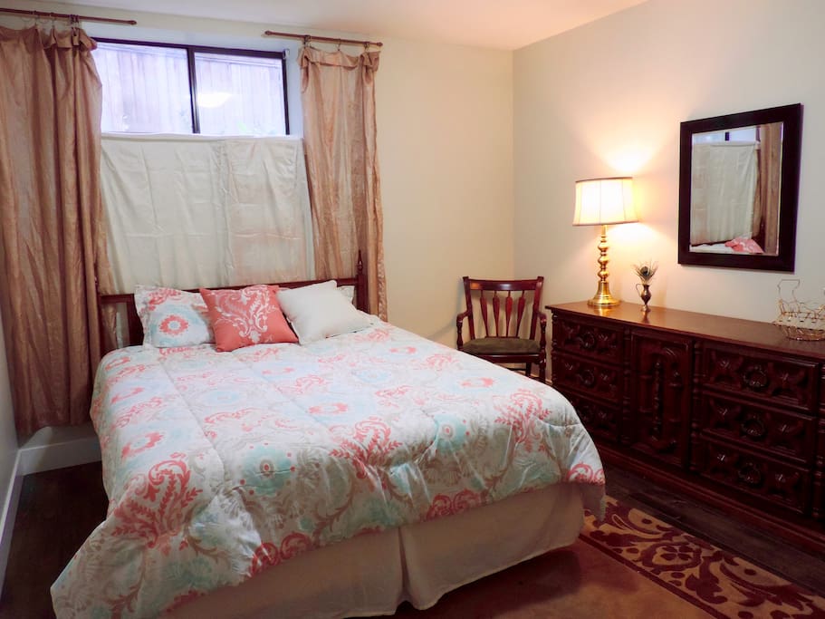 Bedroom with queen bed, dresser, chair and closet