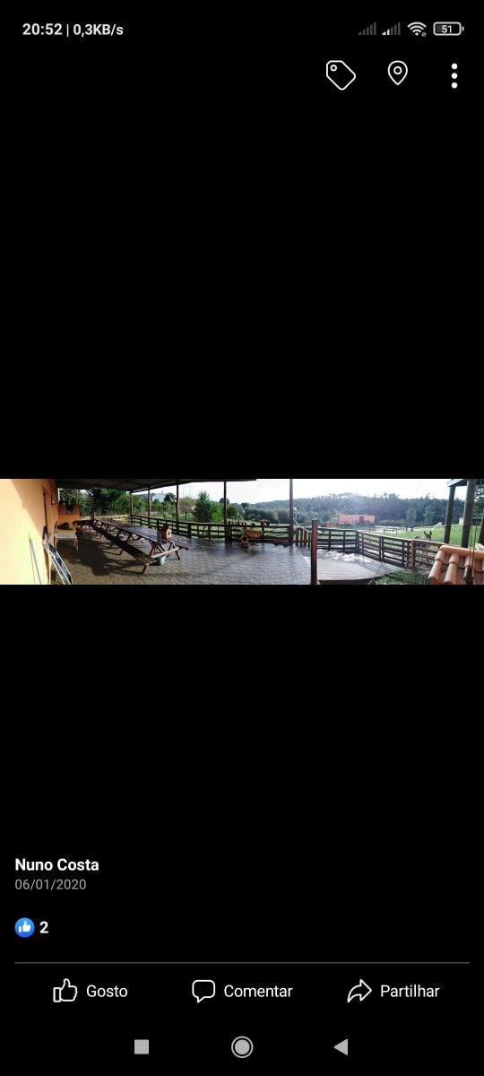 A panoramic view of a spacious outdoor deck features multiple lounge chairs arranged along the railing, overlooking a serene landscape. Lush greenery and distant hills are visible in the background, creating an inviting space for relaxation.
