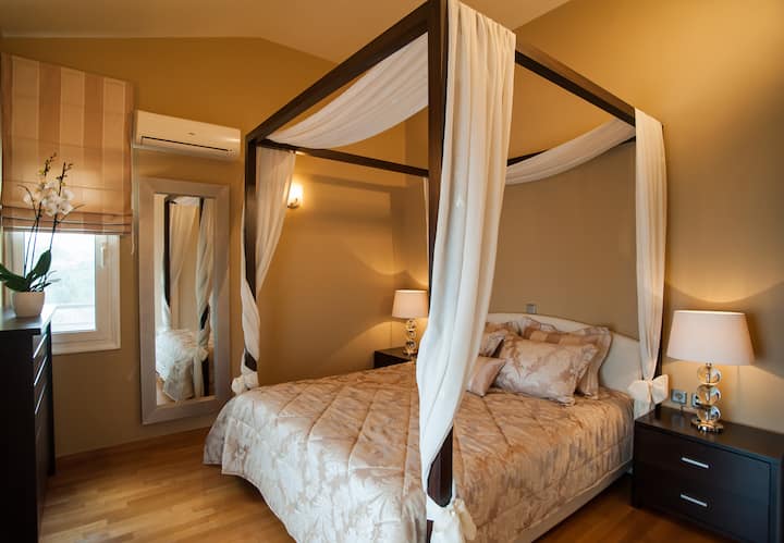 Kitanda maradufu cha kupendeza chenye kifuniko na mapazia mepesi, kinachotoa hisia kama ya hadithi ya kufikirika