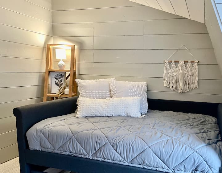 الطابق العلوي: سرير نهاري مزدوج الحجم مع سرير قابل للسحب تحته. 