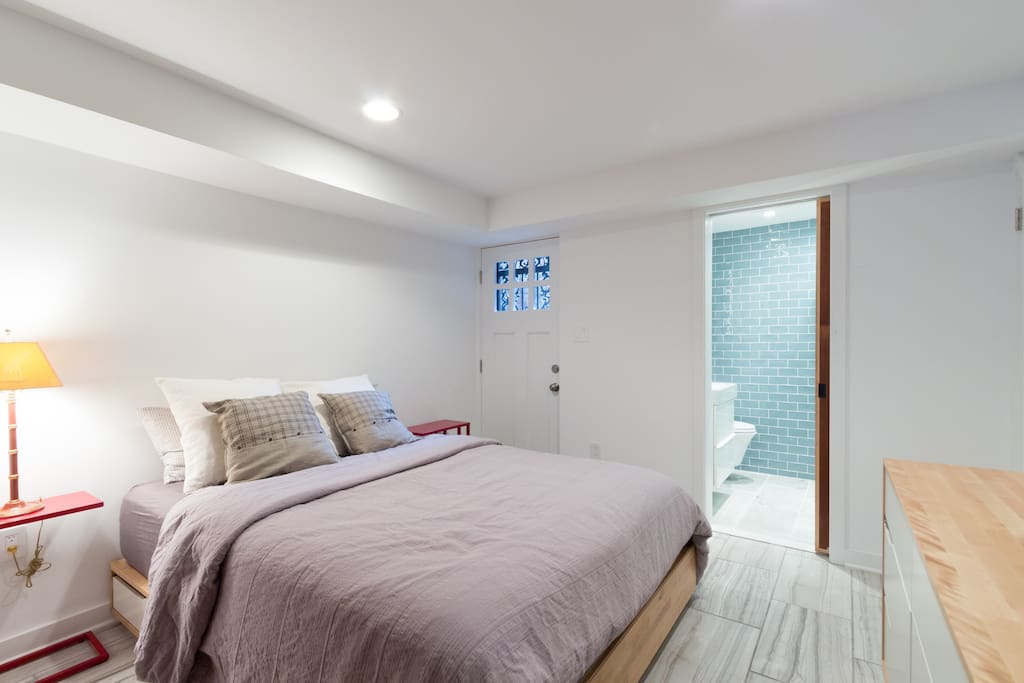 Queen bedroom with hidden closet and drawers and TV