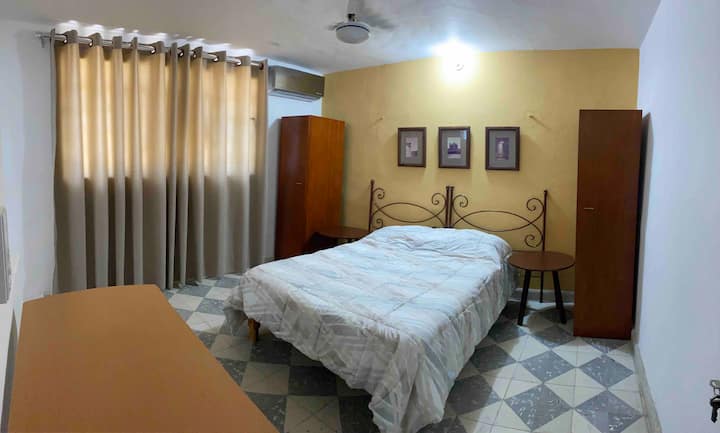 Habitación número 5 con una cama doble, 2 armarios pequeños, aire acondicionado, ventilador de techo, escritorio, silla de escritorio y baño