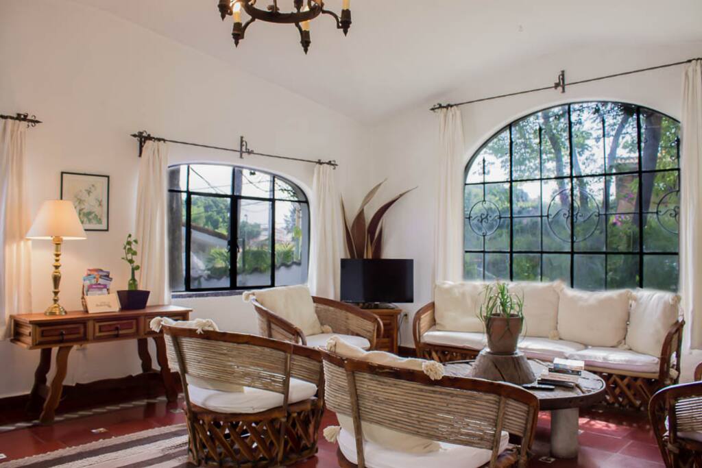 Sala con Smart TV plana y mesa de rueda del siglo 18/Living room with flatscreen Smart TV and coffee table made of an 18th century wheel.