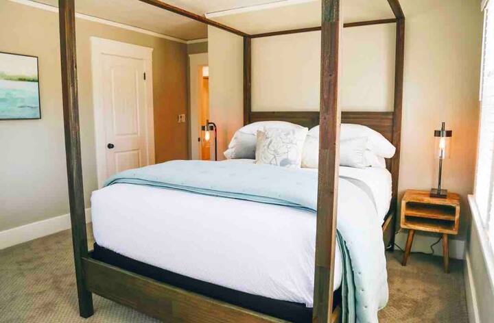 A wooden canopy bed completes another queen bedroom 