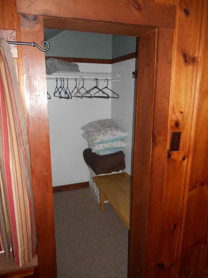 Armario fuera del dormitorio con ropa de cama adicional.