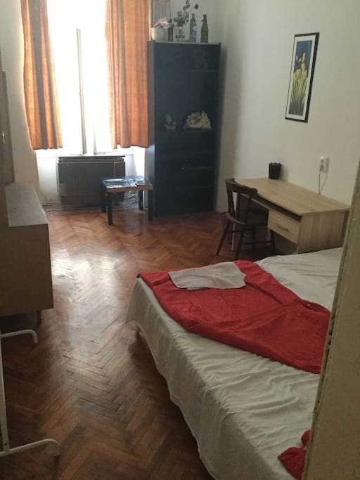 The smaller room, with a large double size bed, cupboards and a desk.