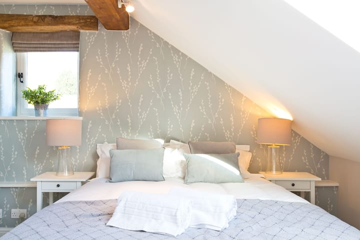 Con vigas tradicionales, este dormitorio 1 tiene una sensación cálida y acogedora.  Una cama doble o individual tamaño king con baño en suite y espacio para una cuna.