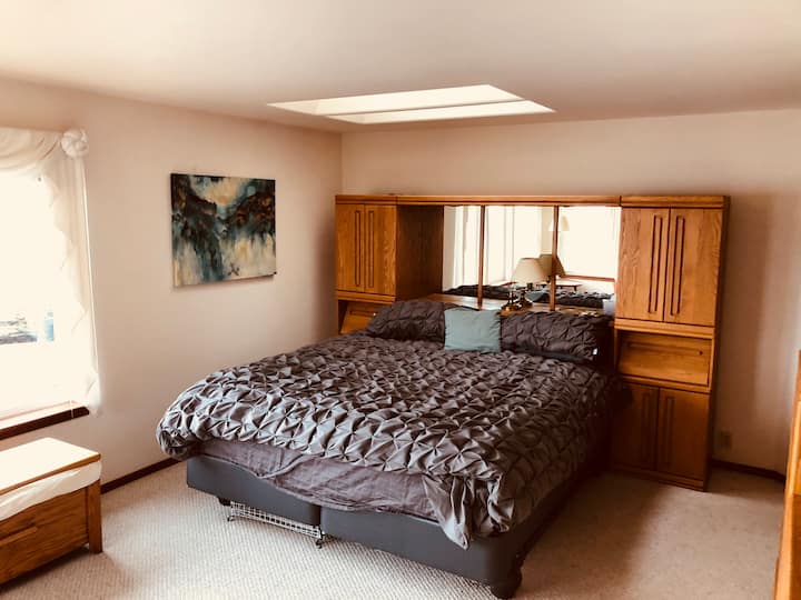 Chumba cha kulala cha msingi chenye kitanda aina ya King, bafu kamili la kujitegemea lenye beseni la kuogea, bomba la mvua na mwonekano wa ufukweni