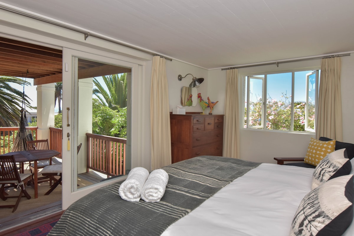 ห้องนอนหลักพร้อมเตียงขนาดคิงไซส์นำไปสู่ดาดฟ้า  มีตู้บิวท์อินและลิ้นชัก