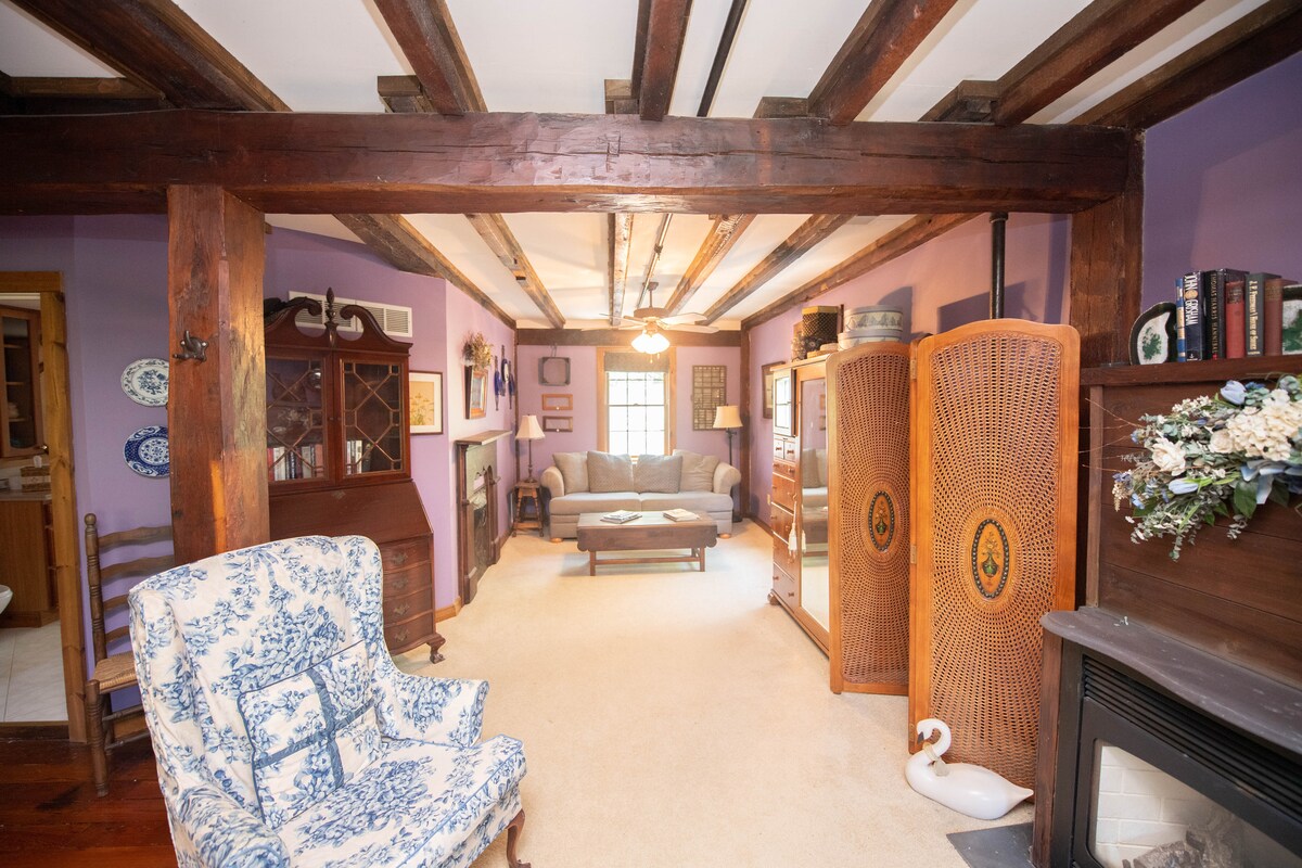 סוויטת המלך שלנו בקומה השלישית עם ראש מיטה היסטורי, ספה, אח וחדר רחצה ושירותים.  