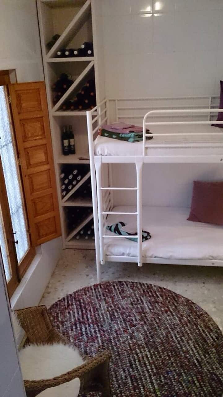 Poschodové postele (2 m) mimo kuchyne. Izba slúži aj ako vínna pivnica