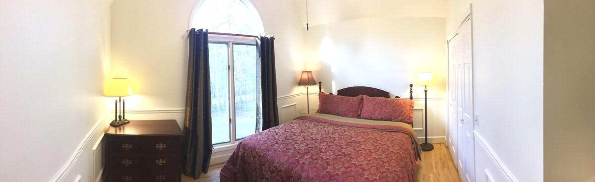 Spálňa s manželskou posteľou King na poschodí s klenutými stropmi