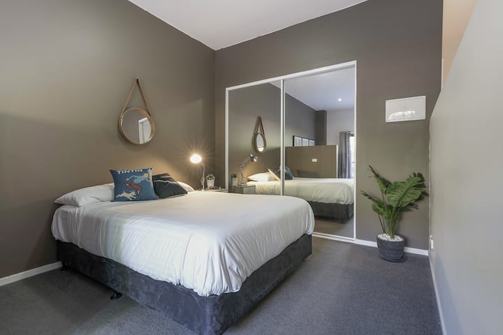 Mirna spavaća soba s bračnim krevetom i sjenilom na bočnoj strani te golemim ogledalom. Savršeno mjesto za opuštanje i dobar san.