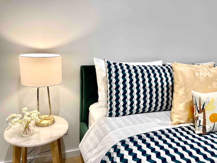 Бегајте во нашата удобна спална соба, каде што современиот дизајн се среќава со удобноста. Креветот е облечен во стилска постелнина. Меката ноќна ламба обезбедува совршено осветлување за читање доцна навечер, обезбедувајќи мирен ноќен сон во ова спокојно засолниште.
