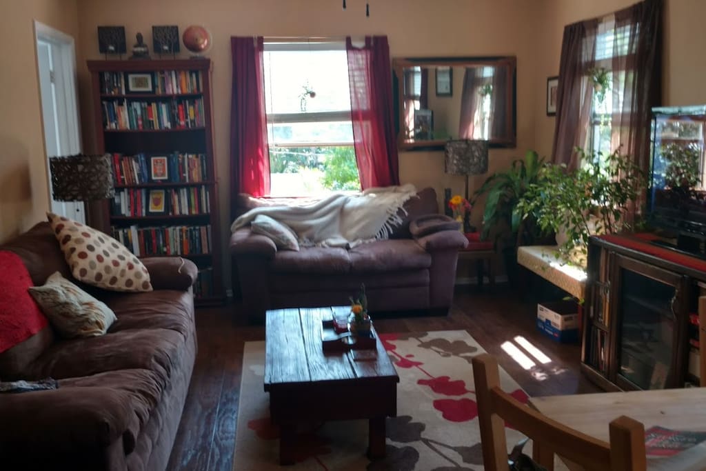 The living room is small, but cozy, and includes access to a television with Chromecast and two well-stocked bookshelves.