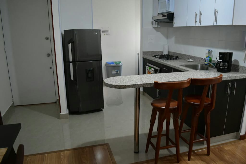 Cocina tipo Americano con Cuarto de Ropas al fondo.