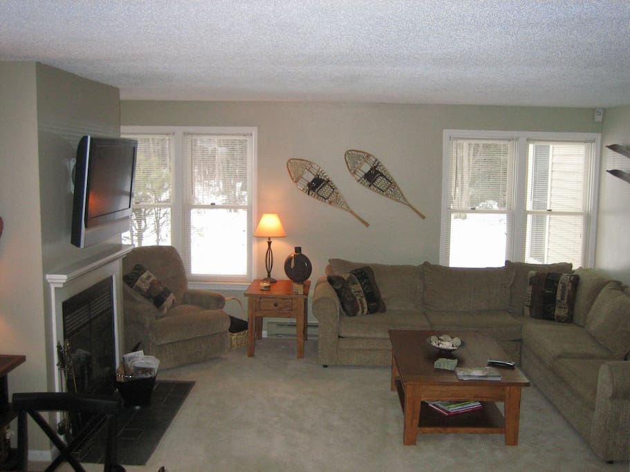 Family room with fireplace and mounted TV with cable.