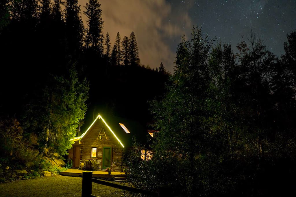 Cabin view at night with lush forest surrounding