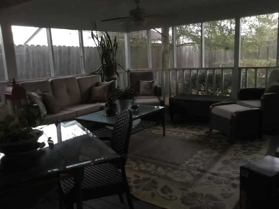 Large screened in porch with BBQ grill, eating and lounging areas, 32 inch tv