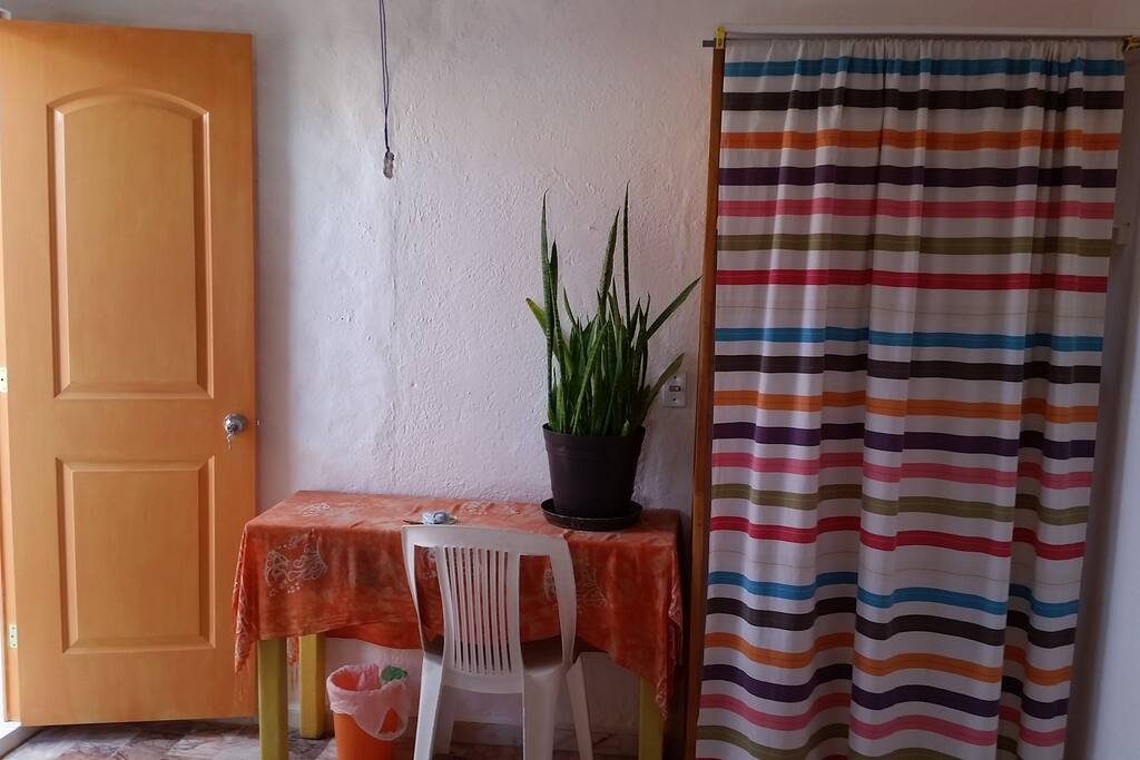 A desk and the closet (behind the curtain)
