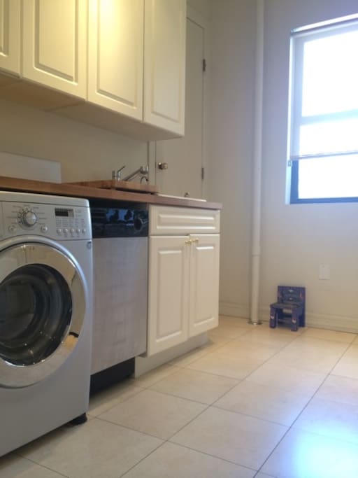 The kitchen features a four-burner electric stove, oven, dishwasher, and a Euro-style combination washer/dryer