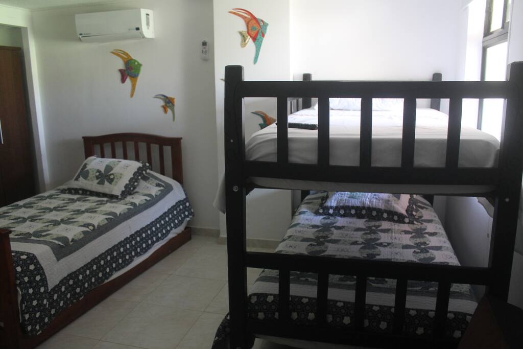 Habitacion auxiliar con camas sencillas, sofacama y aire acondicionado