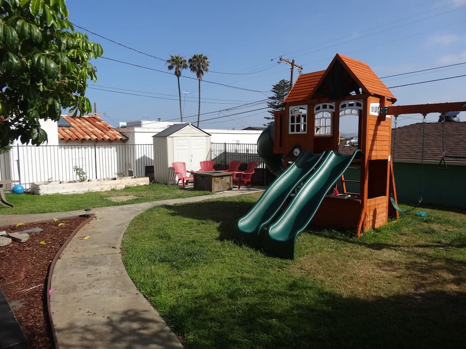 Backyard with play set and gas firepit