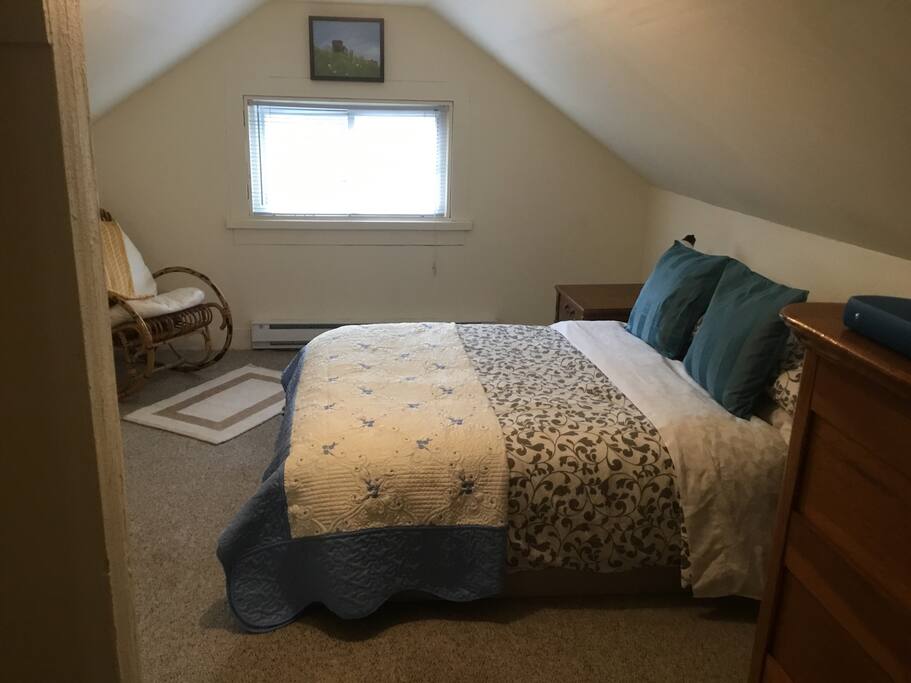 The loft bedroom with double bed, rocking chair and chest of drawers.
