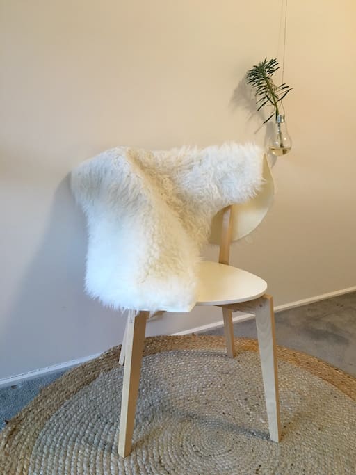 Hand spun jute rug, flowers and chair in bedroom.