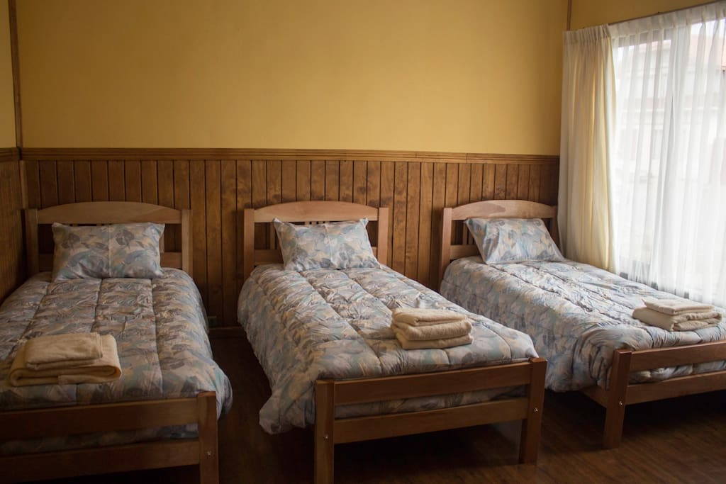 Dormitorio para 3 personas con hermosas camas individuales de madera de lenga completamente equipada