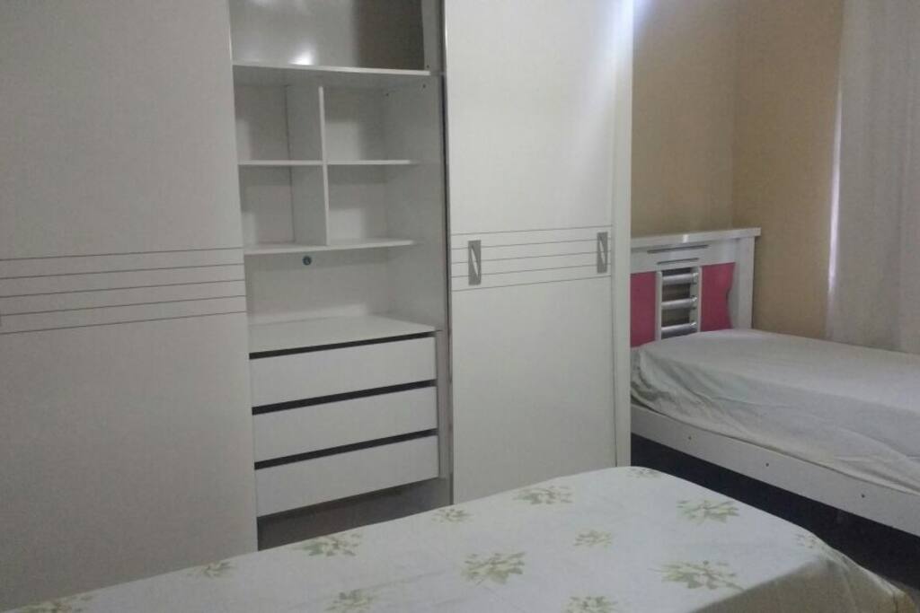 Quarto com duas camas de solteira e colchão extra de solteiro
