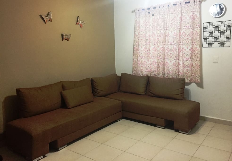 Sala con sofá cama, ventilador y pantalla con Dish.