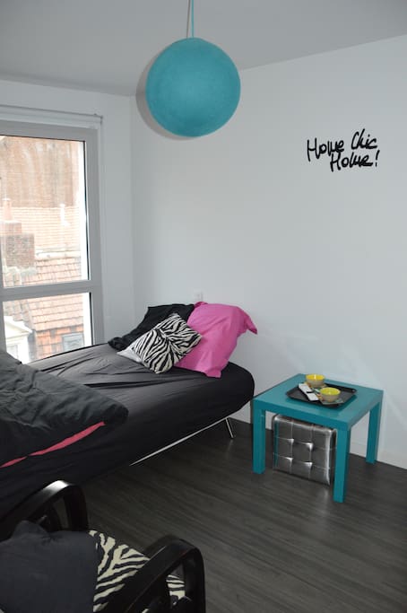 Chambre Airbnb. Situé sur une rue très calme, elle dispose d une TV de deux fauteuils zèbre et d une petite table Ikea.