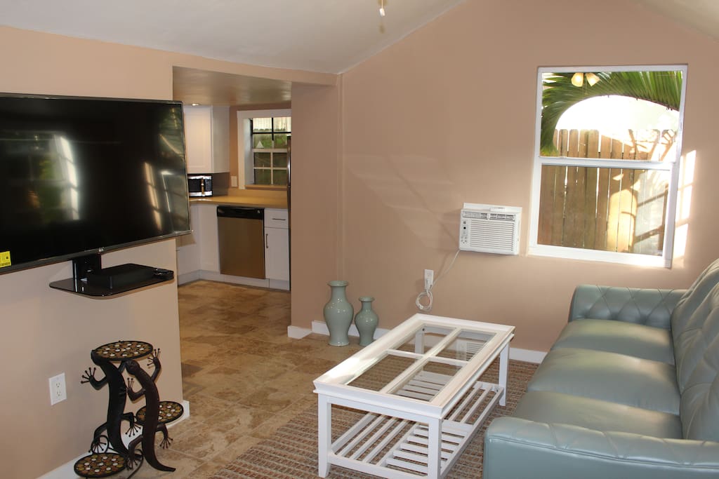 Living Room with comfortable leather sofa (including queen-sized sofa bed) and 50 inch flat screen HDTV.