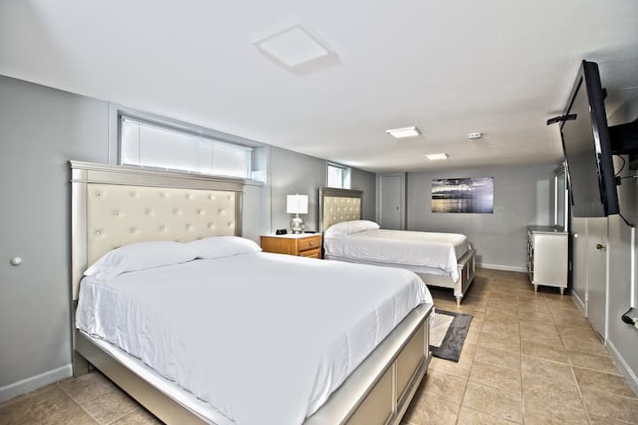 低层卧室（楼梯左侧）：2张标准双人床、带镜子和灯的梳妆台、2个床头柜和2个台灯、衣柜（悬挂衣服）、衣柜（搁架）、2个行李架、75英寸智能高清电视、通往洗衣机/烘干机的门。