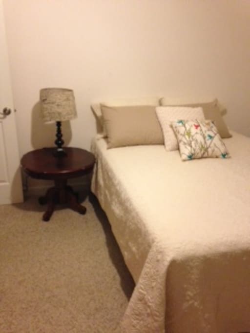 Queen bed with new bedding. Bathroom next to room.