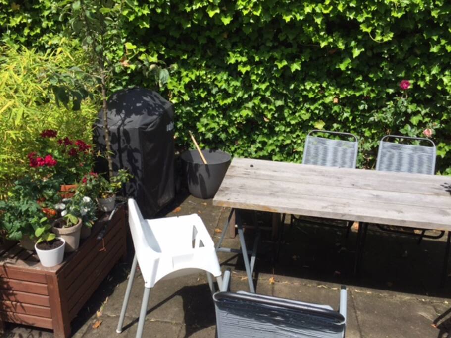 Gas grill and highchair available in cozy garden.