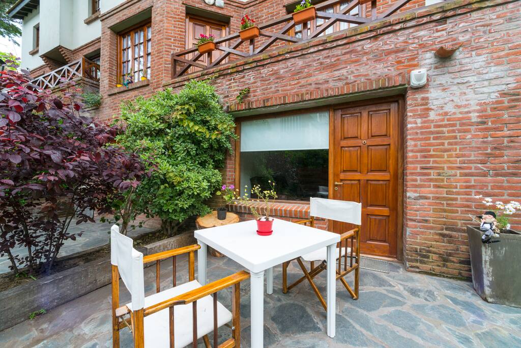 Patio privativo c jardín, mesa y sillas