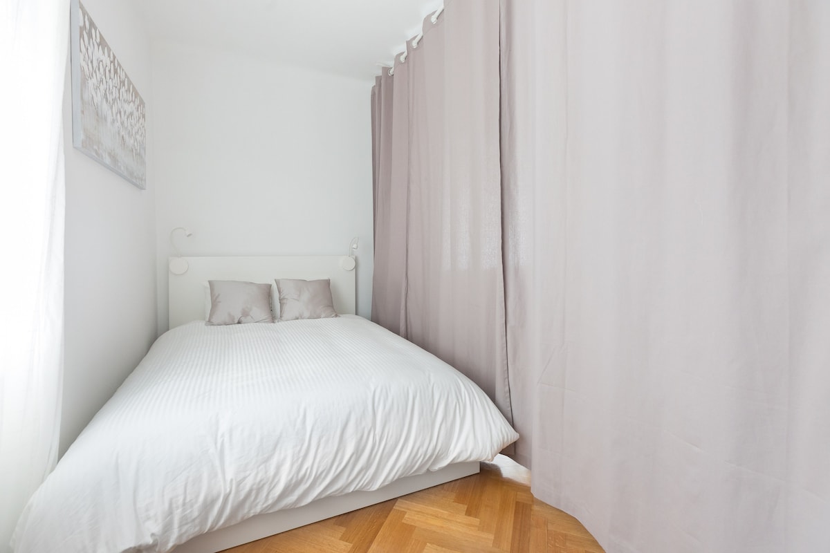 Posteľ v obývacej izbe uzavretá závesmi