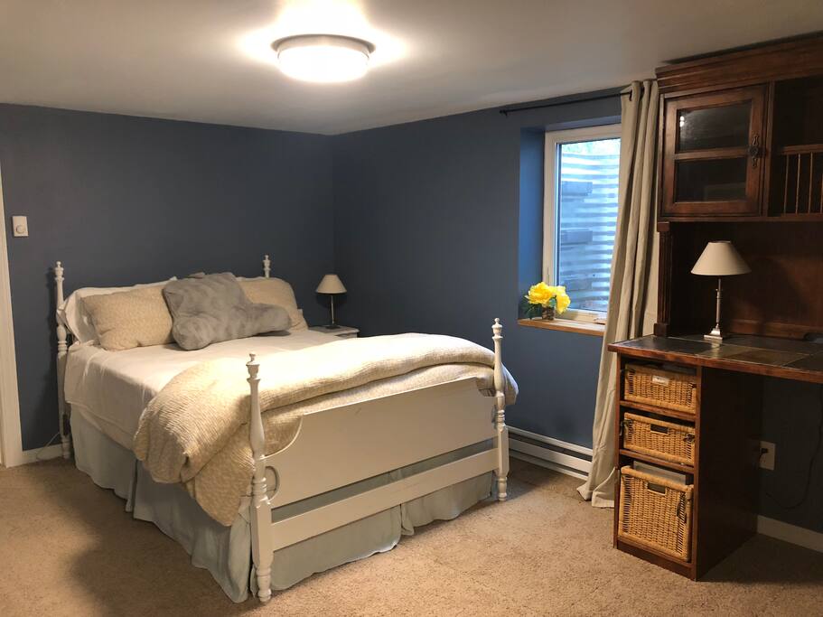 The blue bedroom boasts a comfy queen size bed, large egress window, and lots of storage.