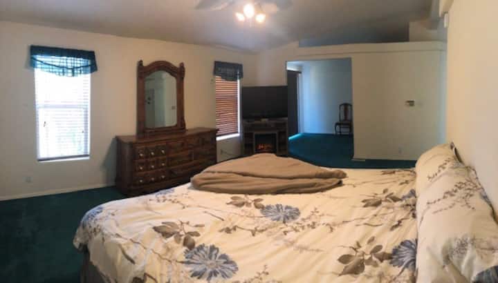 Dormitorio principal con TV y chimenea falsa.  Espacio de trabajo junto al maestro con vista al lago.