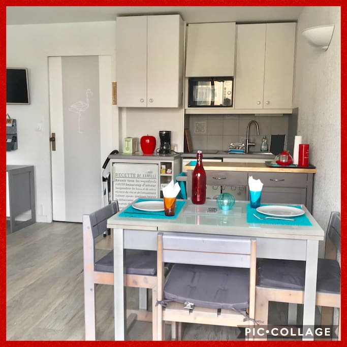 Un coin cuisine avec plaque induction, lave vaisselle, four, cafetière, grille pain, etc... dans la pièce de vie