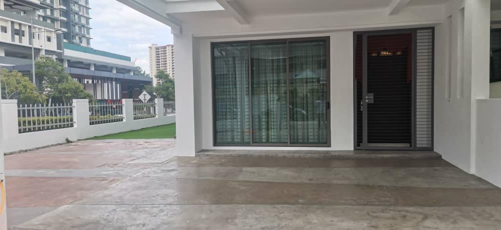A spacious entrance area features a concrete floor, with large glass doors providing natural light. The entrance leads to a welcoming indoor space, complemented by a well-maintained outdoor area visible through the glass. The surrounding landscape includes grass and a fence.