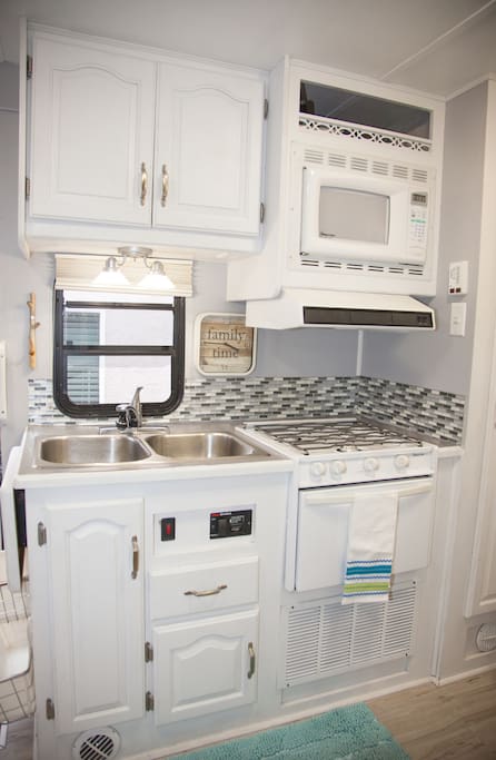 Kitchen is fully stocked with pots, pans, glassware, utensils, and dishes.