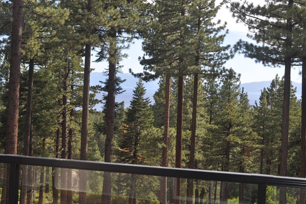 View from the back of our house overlooking forest land and a view of Lake Tahoe through the trees.