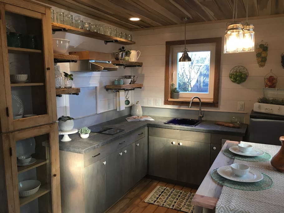 Kitchen with induction cook top, small fridge and sink, and reclaimed 100 year old pantry cabinets
