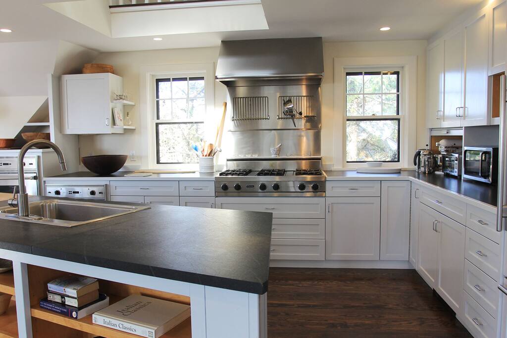 Kitchen enjoys 6 burner gas stove top, two ovens and classic sub zero refrigerator
